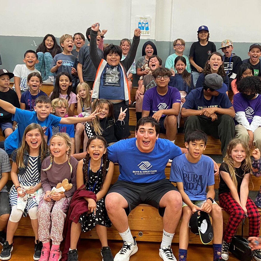 Volunteer hyping up all the kids at the boys and girls club